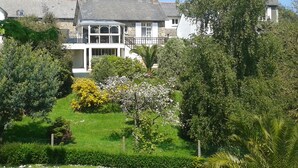 A large, white house with a prominent bay window and a conservatory.