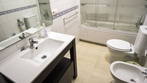 Une salle de bain avec un lavabo blanc, un miroir et une douche à parois de verre.