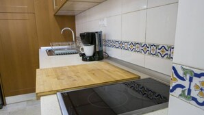 Une cuisine avec un plan de travail en bois, une machine à café et une cuisinière.