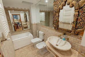 Een bad/douchecombinatie, een haardroger, handdoeken