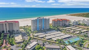 Un complexe hôtelier comprenant plusieurs immeubles de grande hauteur, une plage et un espace piscine.