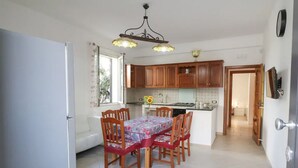 A kitchen with wooden cabinets, a dining table with chairs, and a chandelier. - [Beach-Seafront 5 Stars] Comfortable Holiday Home (Avola)