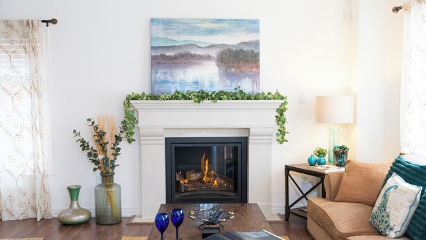 A living room with a fireplace, a sofa, a coffee table with a magazine, and decorative vases. - 🍷 Luxury Pond House, 10 minutes to Niagara Falls (Thorold)