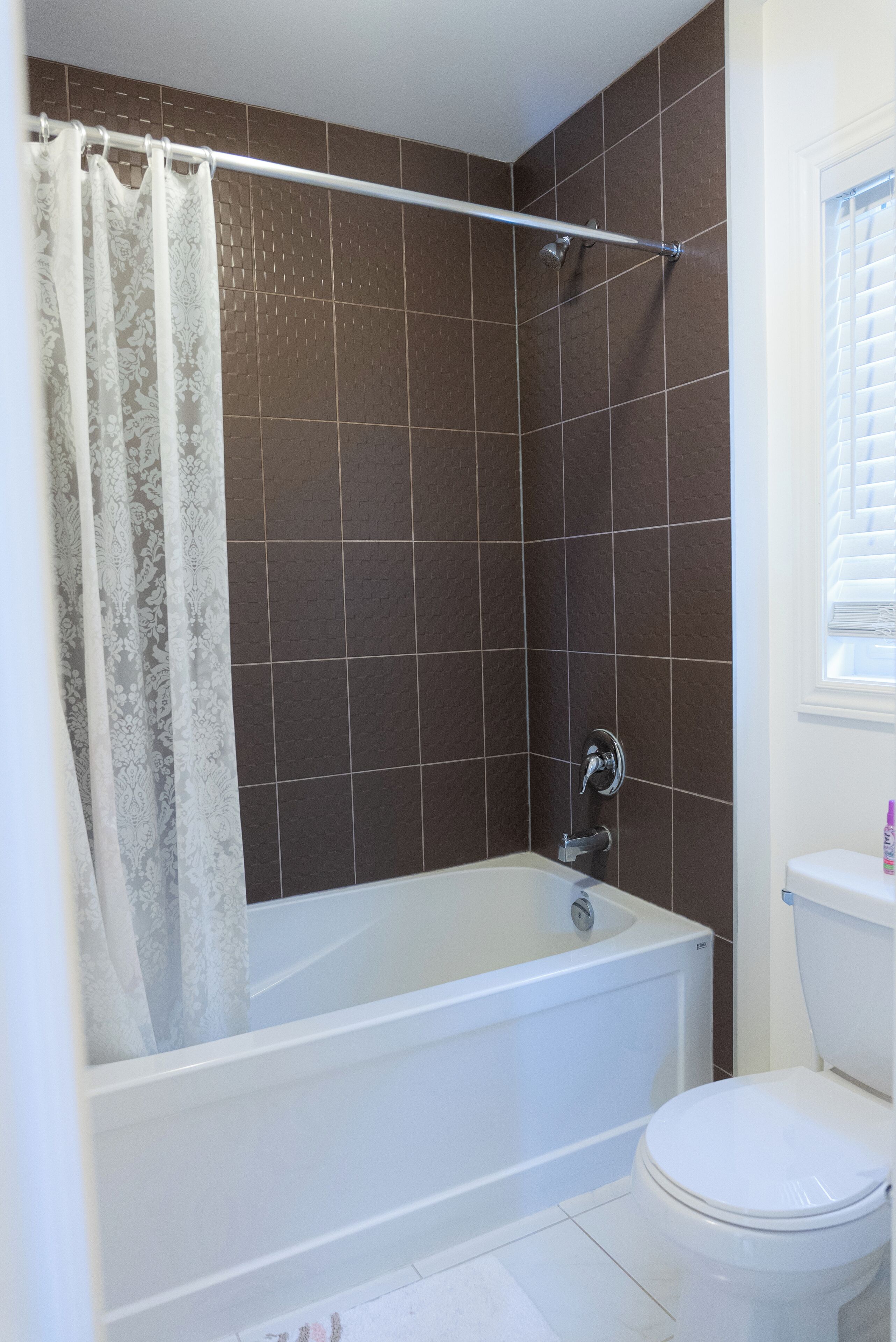 Une salle de bain avec une baignoire, des toilettes et un rideau de douche.