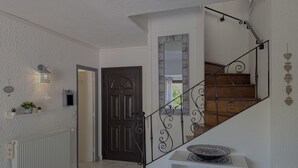 A staircase with a black metal railing and a white console table with a decorative bowl. - Sol-y-Days Grau Village, Holiday home with large terrace (Le Grau-du-Roi)