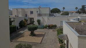 A residential area with modern buildings, a paved courtyard, and a small tree. - Sol-y-Days Grau Village, Holiday home with large terrace (Le Grau-du-Roi)