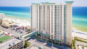 A high-rise hotel with multiple floors, a beach view, and a parking area. - Aqua #404 by Resort Collection (Panama City Beach)