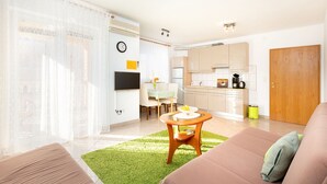 A modern living room with a sofa, a dining table with chairs, and a kitchen area with cabinets and appliances. - Istriensonne 0035 - Ferienwohnung Vilic-3 (Medulin)