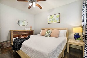 A bedroom with a bed, bedside table, lamp, and a ceiling fan. - Spacious Beach Bungalow: Steps to Beach & Downtown (Lake Worth)