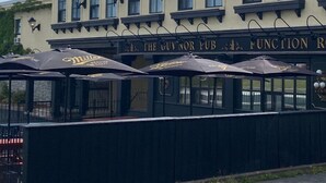 A building with a sign reading "The Guvnor Pub" and "Function Room." There are outdoor umbrellas with logos. - The Guv’nor (St. John's)