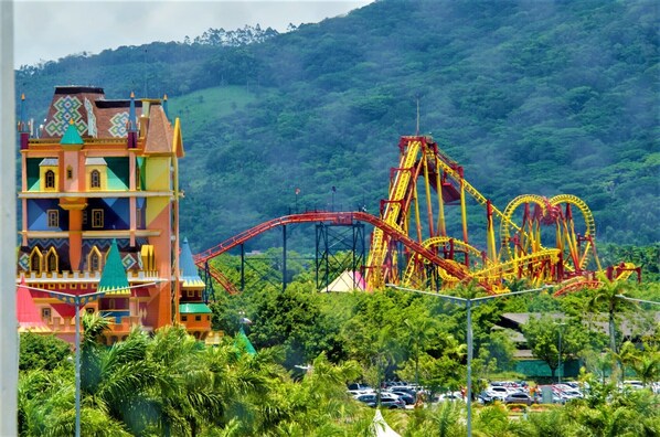 A colorful building with multiple balconies and a roller coaster in the background.