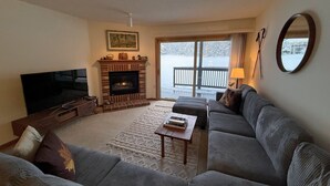A living room with a fireplace, a television, and a sofa.