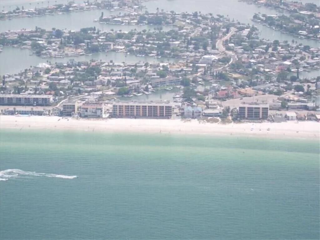 Luftaufnahme einer Küstenregion mit einem Hotel direkt am Strand.