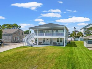 A two-story house with a balcony, a covered porch, and a well-maintained lawn. - Dream house in NMB, short walk to the ocean (North Myrtle Beach)