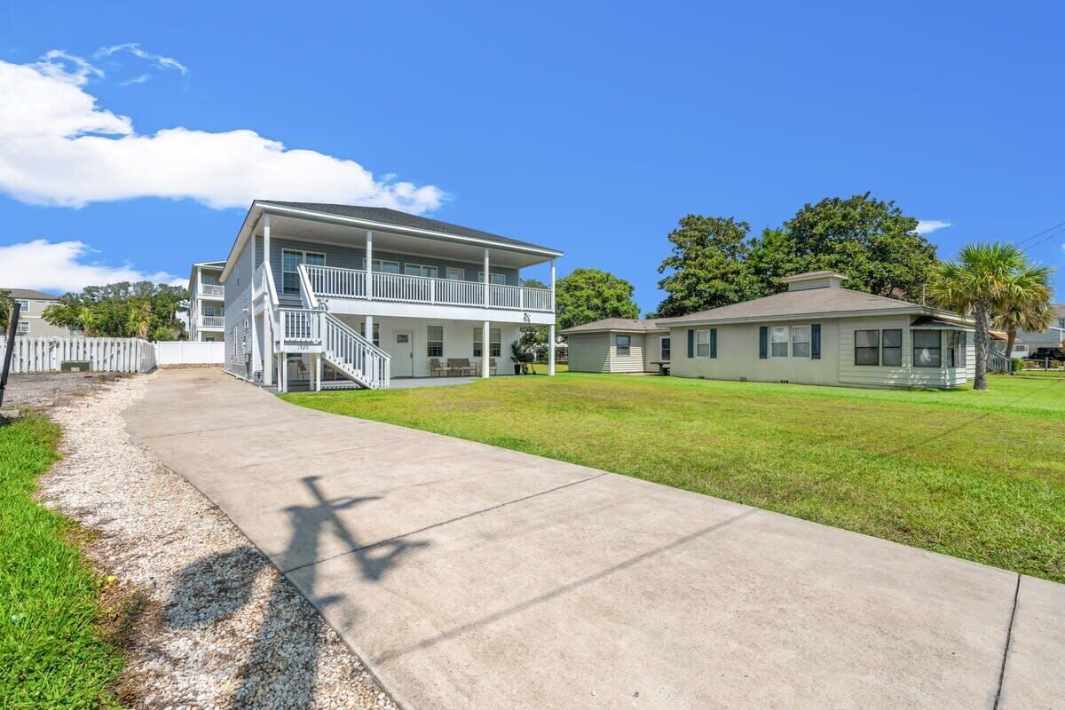 A two-story residential building with a covered porch and a separate garage.