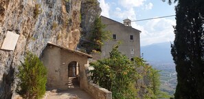 Un bâtiment en pierre doté d’un clocher, d’un étroit passage et offrant une vue sur une vallée.