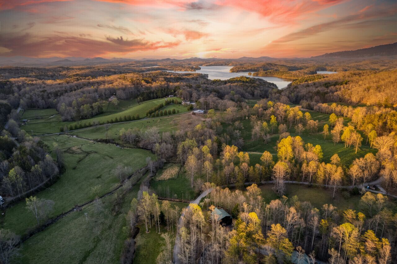 Une vue aérienne d’un paysage rural, avec des champs, des arbres et un petit bâtiment.