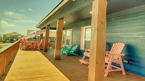 Terraza de madera con mobiliario exterior y un espacio cubierto.