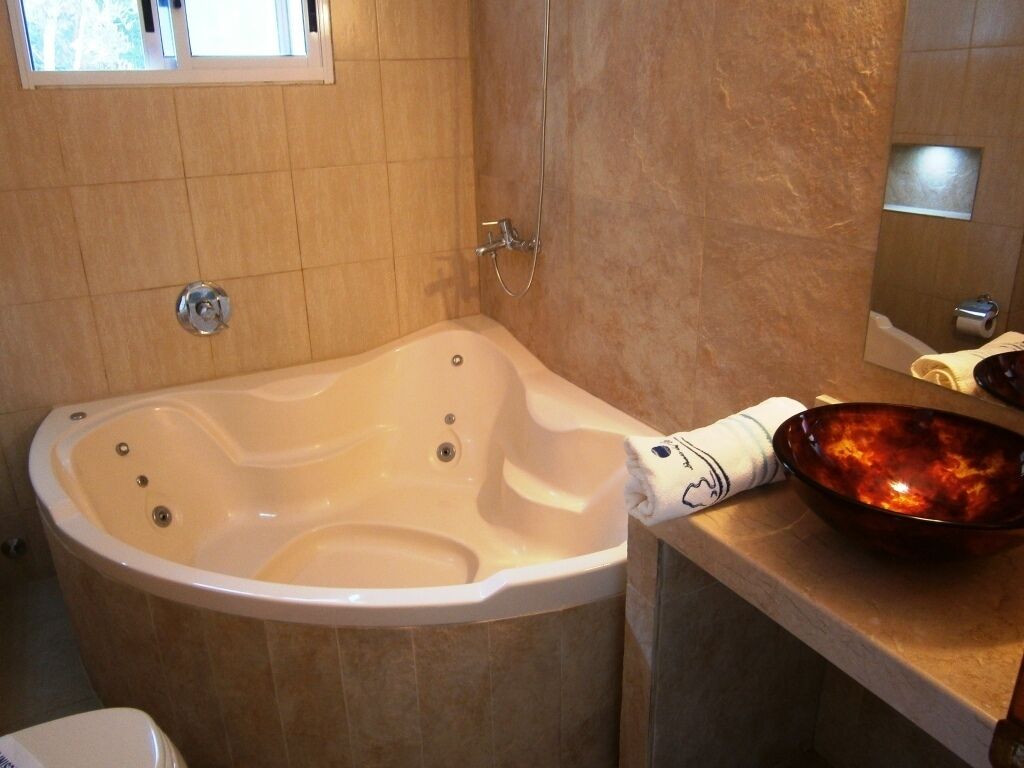 A bathroom with a freestanding bathtub, a mirror, and a bowl on the countertop.