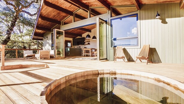 A wooden deck with a swimming pool, outdoor seating, and a view of the surrounding trees. - Hidden Oasis Hot Tub-Disney Train Track. (Julian)