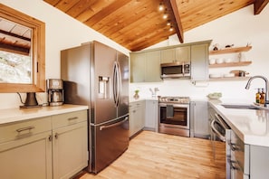 Enjoy cooking in this well-equipped kitchen with a refrigerator, oven, microwave, and sink.