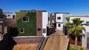 A modern building with solar panels, a green wall, and a staircase leading to a courtyard. - Amplio departamento, con la mejor ubicación en la ciudad (Chihuahua)