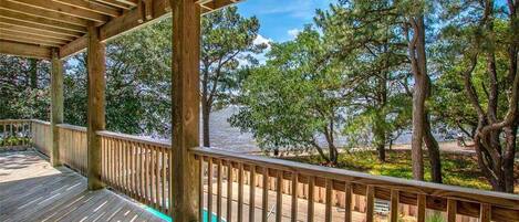 A wooden deck with a view of a lake and trees.