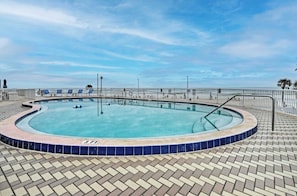 Ein Pool mit 90 Zentimetern Länge, einer mit Fliesen belegten Liegefläche und einem Metallgeländer.