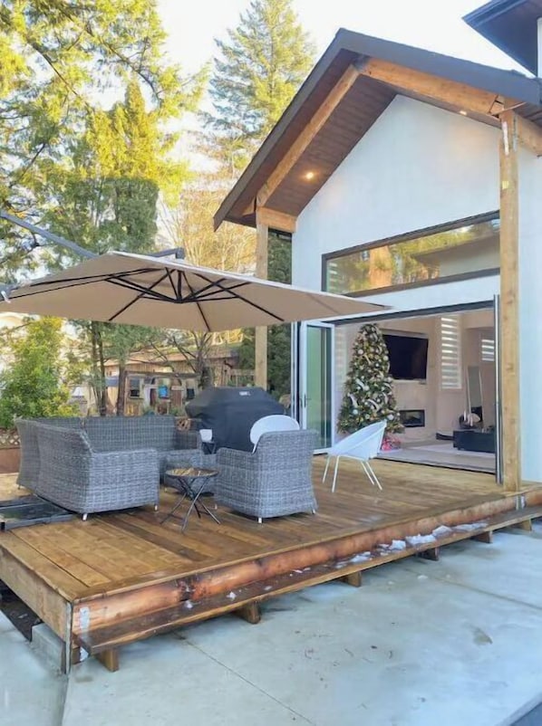 A modern house with a deck, outdoor furniture, and a Christmas tree. - Luxury 5 BR home w/ pool perfect for a getaway. (Langley)