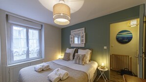 Een slaapkamer met een bed, nachtkastje en een raam.