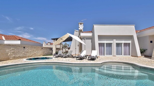 A modern pool area with lounge chairs and a clear blue pool. - Casa Siesta with swimming pool, jacuzzi & garage (Štrika (Istria))