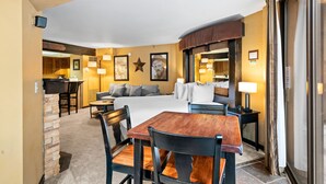 A hotel room with a bed, a dining table with chairs, a kitchenette, and a bathroom visible through an open door. - Silver King 206 | 150 Yards to Lifts | Fireplace | Kitchen | Pool & Hot Tub (Park City)