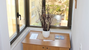 A room with a skylight, a wooden cabinet, and a decorative branch.