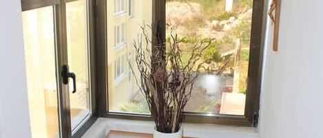 A room with a skylight, a wooden cabinet, and a decorative branch.