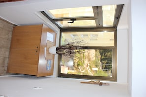 Enjoy the serene ambiance of this stylish room with a skylight window, a wooden cabinet, and a decorative branch.