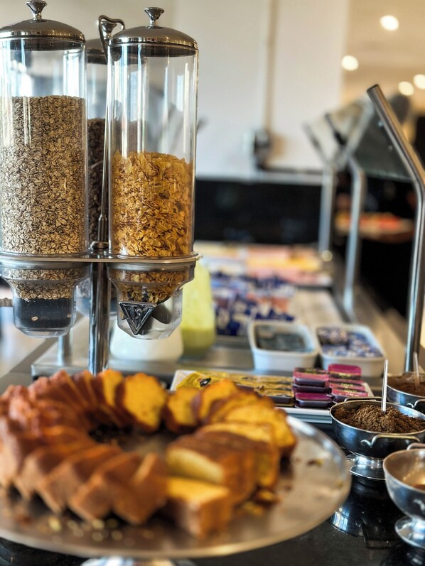 Un bufé de desayuno con diversos alimentos y recipientes.