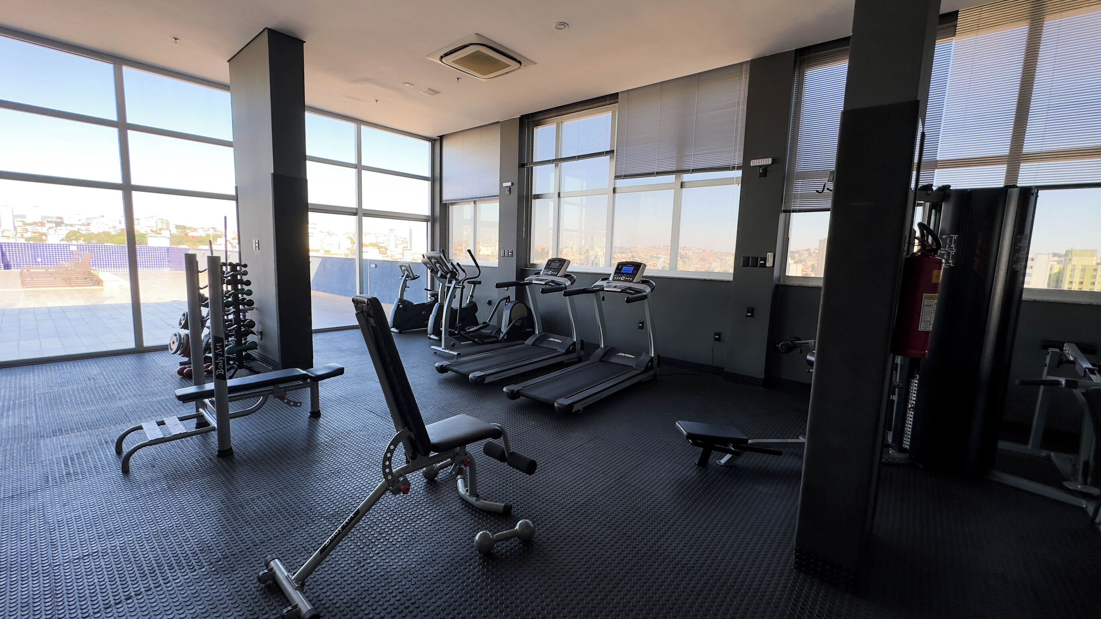 Un gimnasio con cintas de correr, elípticas y máquinas de pesas.