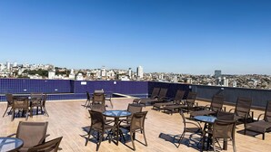 A rooftop terrace with outdoor seating and a city view. - Gran Vivenzo Cidade Nova (Belo Horizonte)