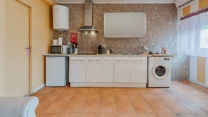 A compact kitchen with a washing machine, a microwave, and a built-in oven. - Y.Quebedo - Boutique Apartments - Poetico (Setúbal)