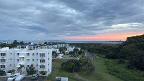 A residential area with white buildings, a parking lot, and a view of the sea at sunset. - Apartment with ocean view near Ceiba FerryTerminal (Ceiba)