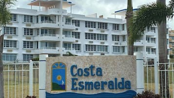 Señal de hotel Costa Esmeralda, con un edificio moderno al fondo.