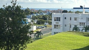 Une zone herbeuse avec un bâtiment blanc et un ciel dégagé.