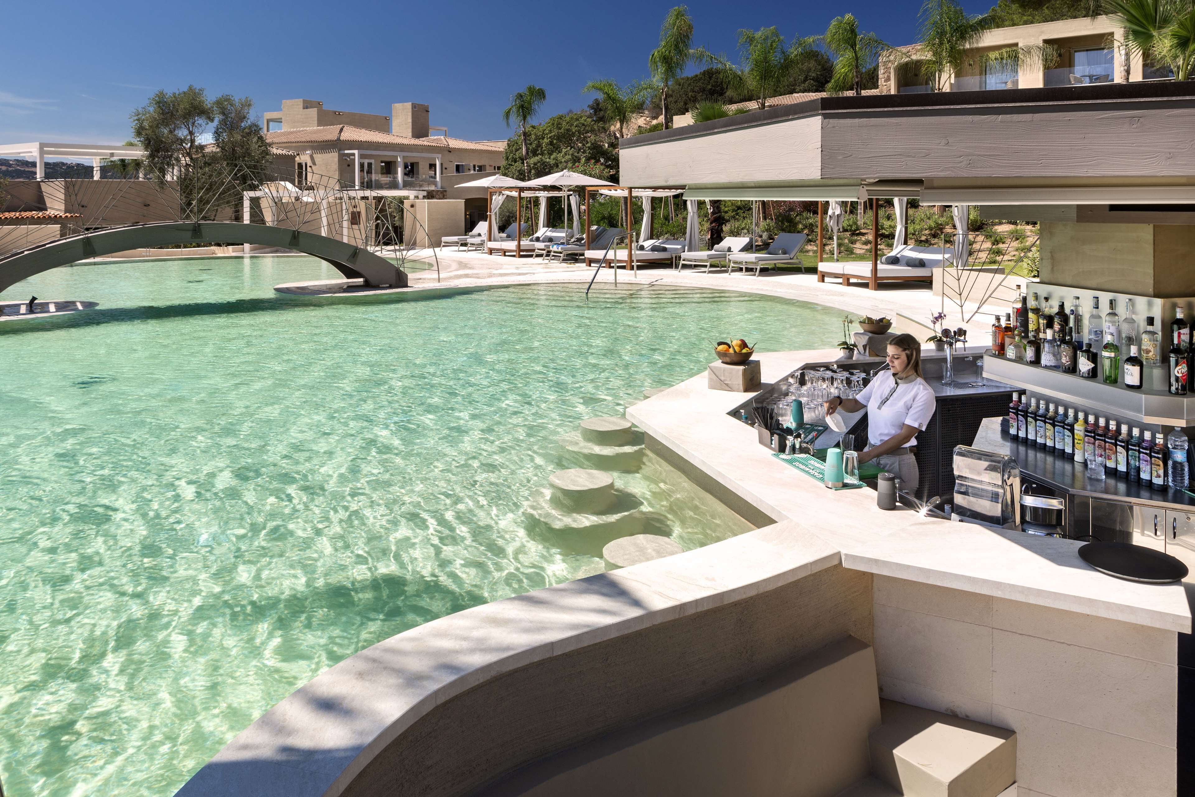 Eine Poolbar mit Liegestühlen und einem klaren Schwimmbecken.