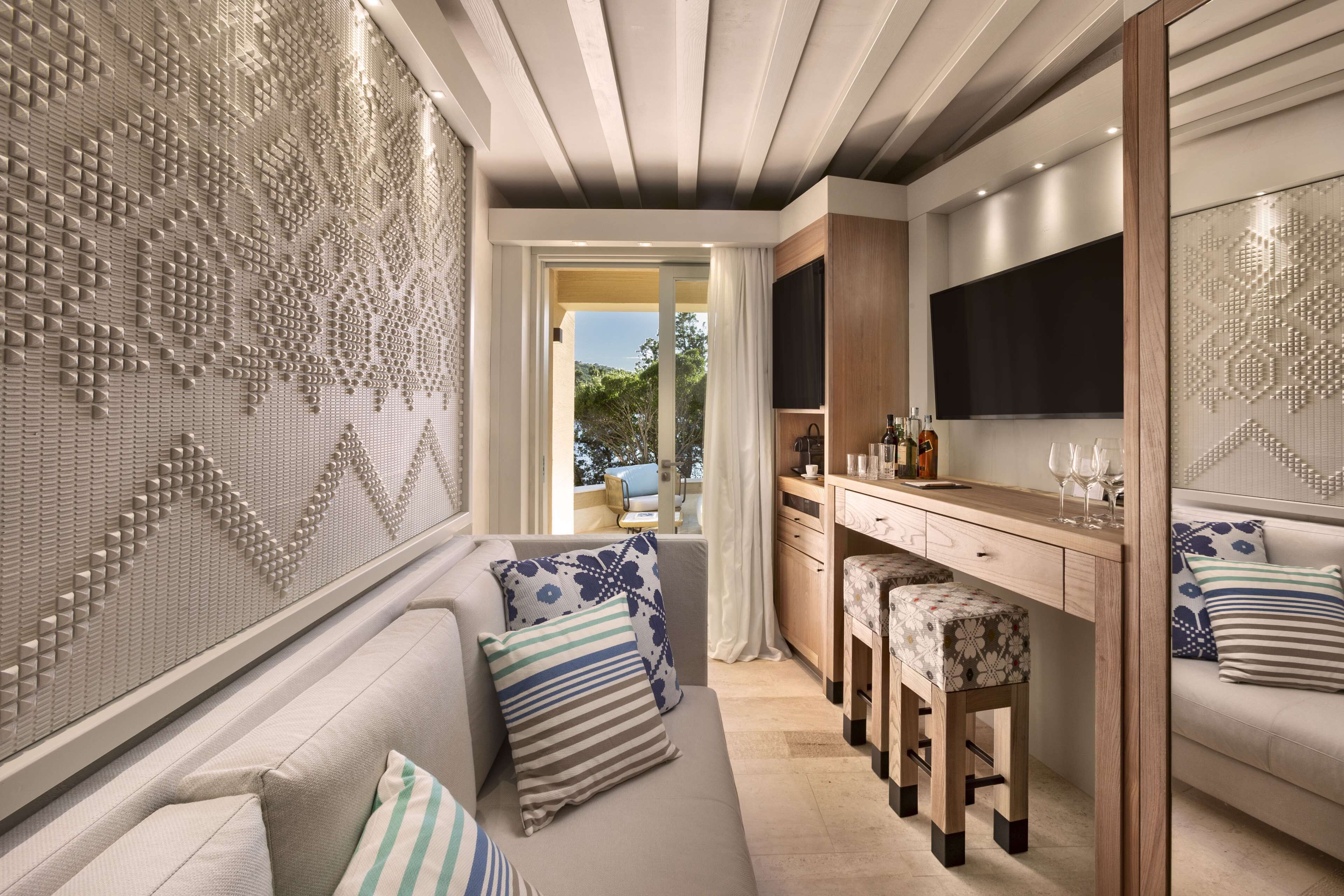 A modern kitchen with a wooden countertop, bar stools, and a built-in TV.