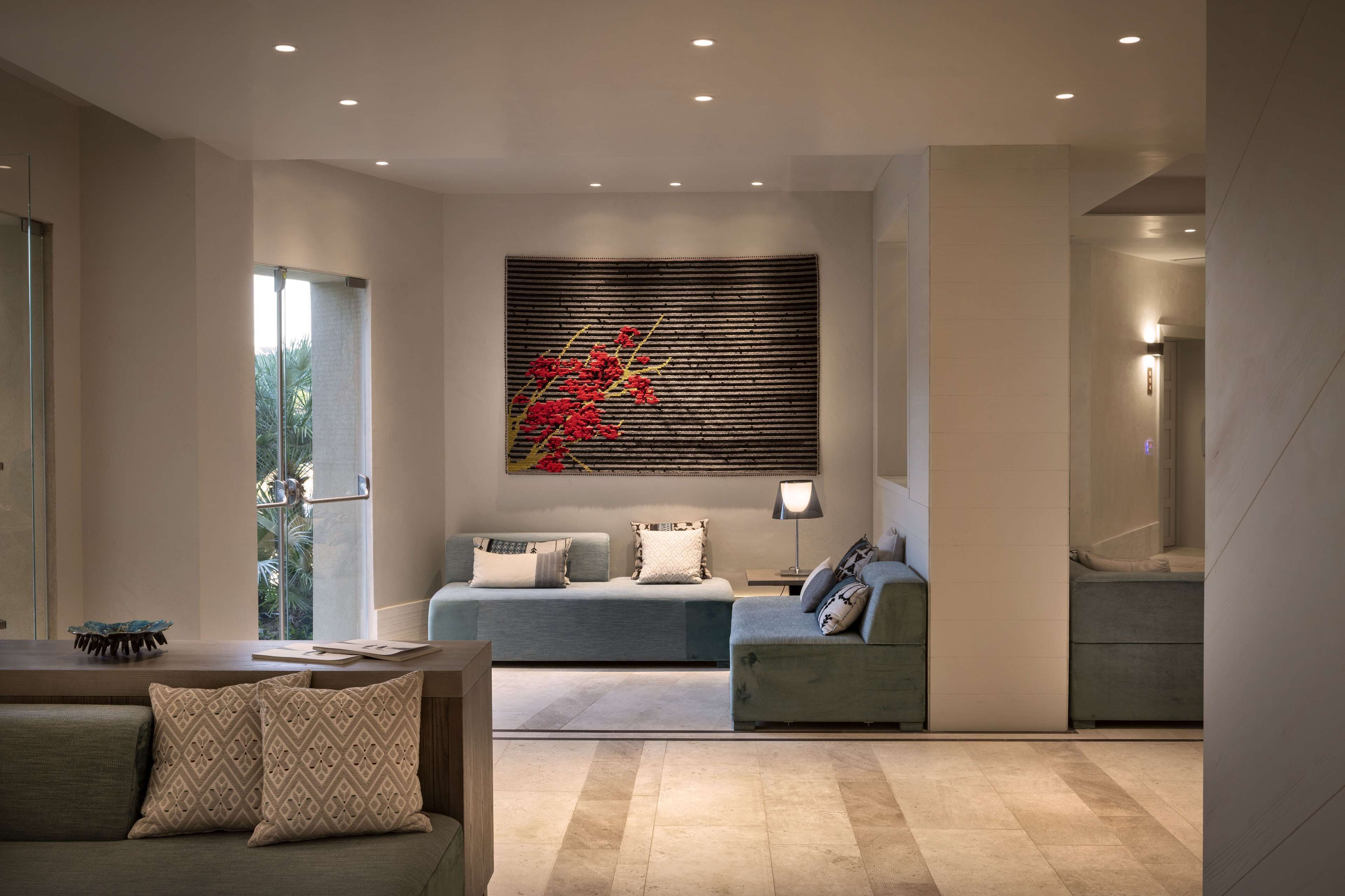 A modern living room with a sofa, a coffee table, and a decorative wall piece.