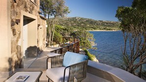 Un balcon doté de meubles en osier et offrant une vue sur la mer.
