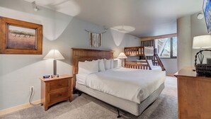 A bedroom with a large bed, a nightstand, a dresser, a lamp, a painting, and a bunk bed in the background. - Silver King 314 | 150 Yards to Lifts | Fireplace | Kitchen | Mountain View | Pool & Hot Tub (Park City)