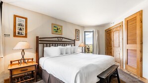 A neatly arranged bedroom with a wooden bed, bedside tables, and a bench.