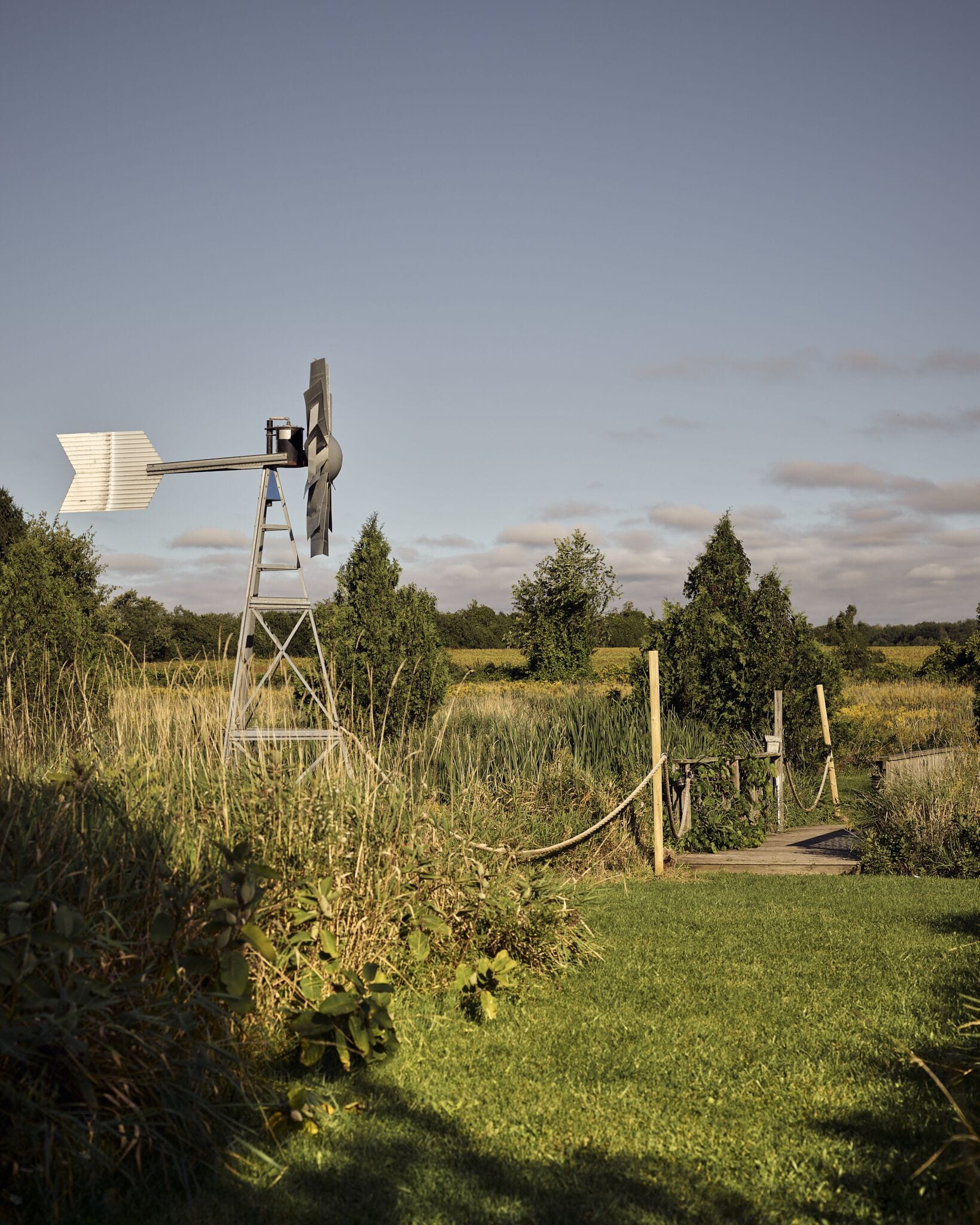 A windmill in a rural setting with a clear sky.