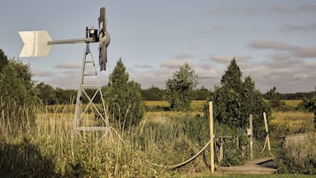 A windmill in a rural setting with a clear sky.